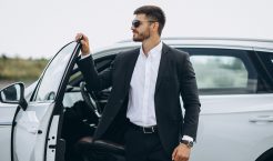Handsome business man by the white car